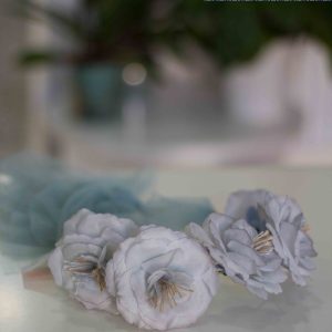 Corona 250 con flores blancas y azul con lazo verde agua para comunión